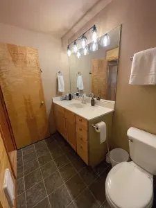 The bathroom has a shower/tub combo and a large vanity with plenty of counterspace.