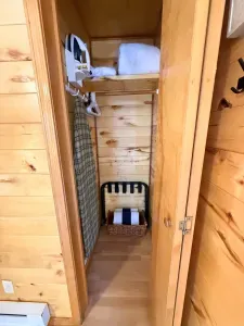 Well-stocked closet with iron, hangers, linens & luggage rack