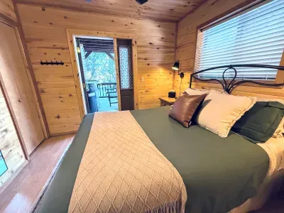 Cozy cabin bedroom with deck access and hot tub just outside