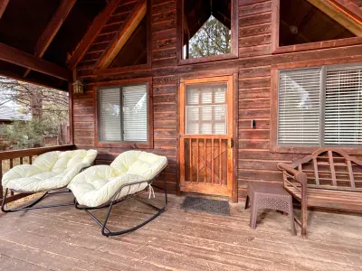 Cozy covered cabin porch with rocking chairs and rustic wood charm