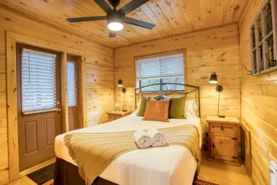 The primary bedroom has a queen size bed and a door to the deck with hot tub.