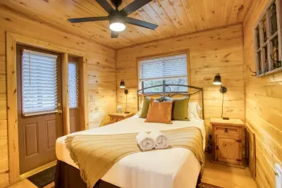 The primary bedroom has a queen size bed, and the entrance to the back deck with the private hot tub. 