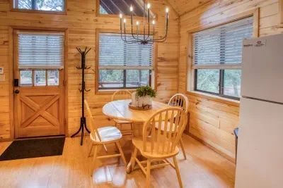 The dining room is open to the living area. The large windows provide lots of natural light and views of the ponderosa pines. 