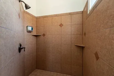 Giant corner shower with shampoo, conditioner, and body wash provided.