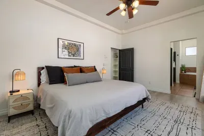 Another view of the primary bedroom showing the large, full-length mirror and entrance to the en-suite bathroom.