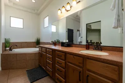 Primary bathroom has a large vanity with double sinks, soaker tub, separate toilet, and giant corner shower. 
