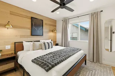 Second bedroom with cozy king-sized bed, full-length mirror, and closet.