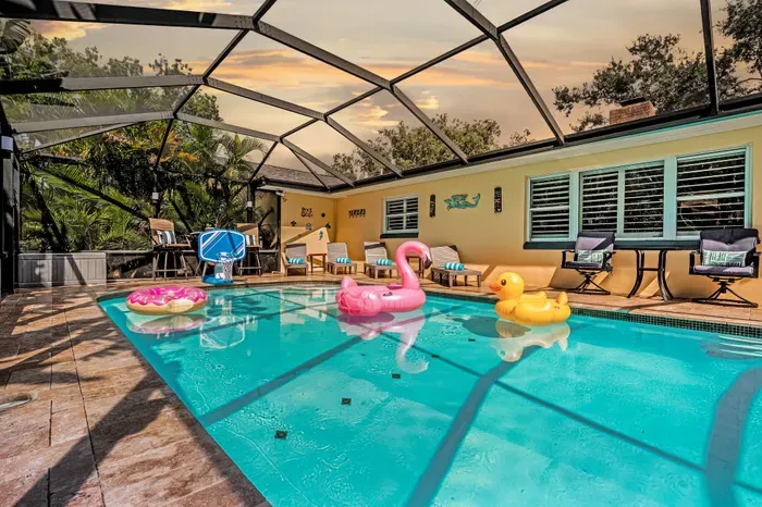 Private screened pool with tropical vibes, lounge seating & sunset ambiance