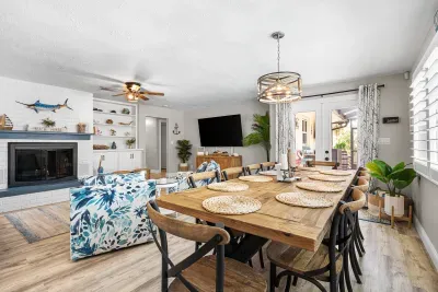 The dining table invites everyone to share meals and make memories, while the comfortable coastal-inspired living area offers plenty of room to relax. With easy access to the outdoor retreat, it’s the perfect heart of the home for family and friends.