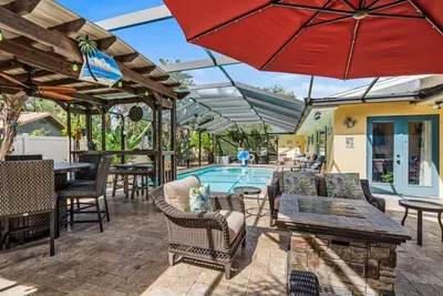 A private tropical retreat with a sparkling pool, spacious covered patio, comfortable lounge seating, outdoor dining, and a cozy fire table, this backyard oasis has everything you need to swim, sip, relax, and make memories together.