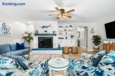 Bright coastal living room with fireplace, TV, and stylish seating