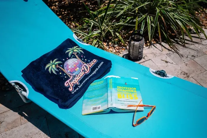 Full backyard overview — outdoor dining for 6, lounge chairs with pool noodles, private pool, and giant Connect Four. Gulfport/St. Pete, FL.