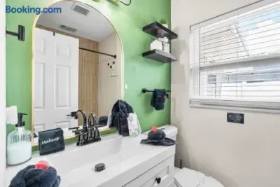 Bright modern bathroom with bold accent wall and stylish arched mirror