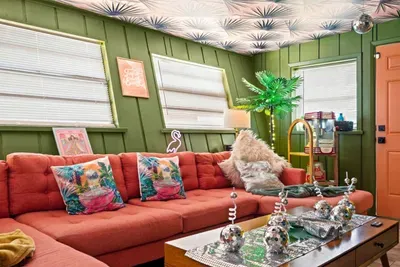 A shimmering disco ball, neon lighting, tropical décor, and bold botanical ceiling create an unforgettable atmosphere