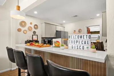 'Welcome to Tropical Disco' kitchen bar — charcuterie spread, Keurig coffee station, quartz countertop. St. Petersburg, FL vacation rental.