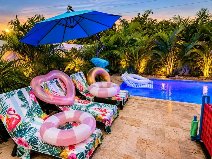 Step into your own tropical poolside paradise. Loungers, pool floats, lush palms, and sparkling water create the perfect setting for sun-soaked afternoons and relaxing evening swims. Float, lounge, sip, repeat—this is what vacation is all about.