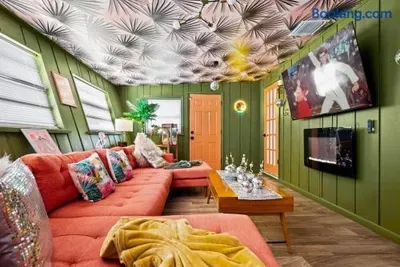 Bold retro lounge with coral sectional, fireplace, and stylish TV area