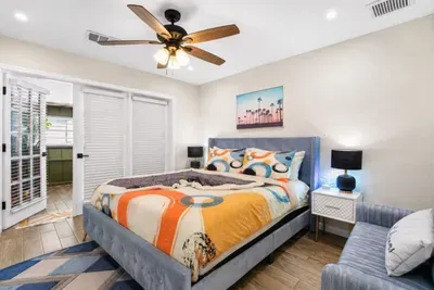 King Retro king bedroom with a blue velvet bed, luxury beddings, colorful 1970s-inspired details, and French doors leading to the disco lounge area..