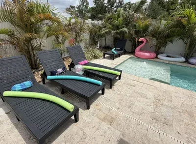 Private pool deck with lounge chairs, pool noodles, and floats included. Fully fenced, tropical landscaping, sleeps 10. Gulfport/South St. Pete, FL.