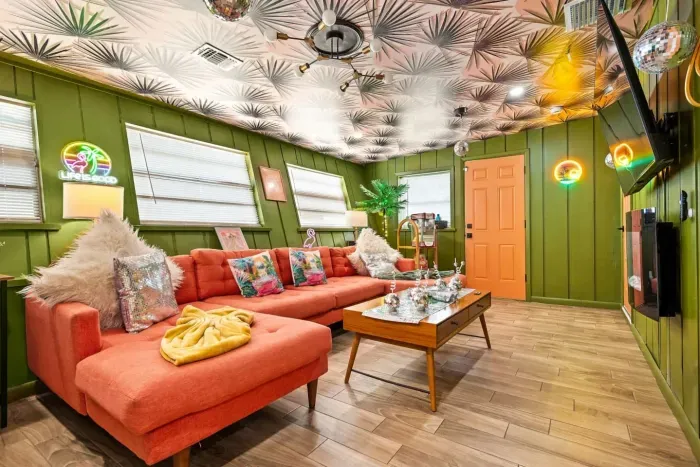 The signature Disco Lounge at Tropical Disco—a vibrant 70s-inspired gathering space with disco balls, a record player, vinyl collection, tropical décor, vintage lighting, and comfortable seating for the whole group.
