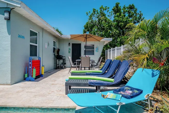 Full backyard — private pool, lounge chairs, outdoor dining for 6, propane grill, and giant Connect Four. St. Petersburg, FL vacation rental.