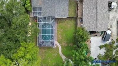Private screened pool and spacious backyard surrounded by mature trees