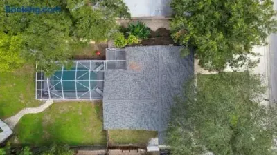 Private home with screened pool, large yard, and leafy surroundings