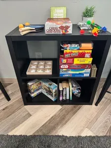 Game room shelf at this St. Pete vacation rental stocked with Scrabble, Battleship, Sorry, Connect 4, UNO, Hot Takes, ping pong, darts, puzzles, and more — entertainment for every age.
