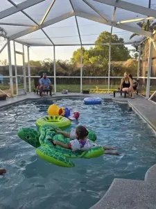 Family relaxing in the private screened pool with floats at this St. Petersburg, vacation rental — the kind of afternoon that keeps guests coming back.