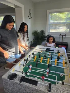 Guests enjoying the foosball table in the game room of this family-friendly vacation rental in St. Petersburg, FL — fun for all ages, steps from the pool.