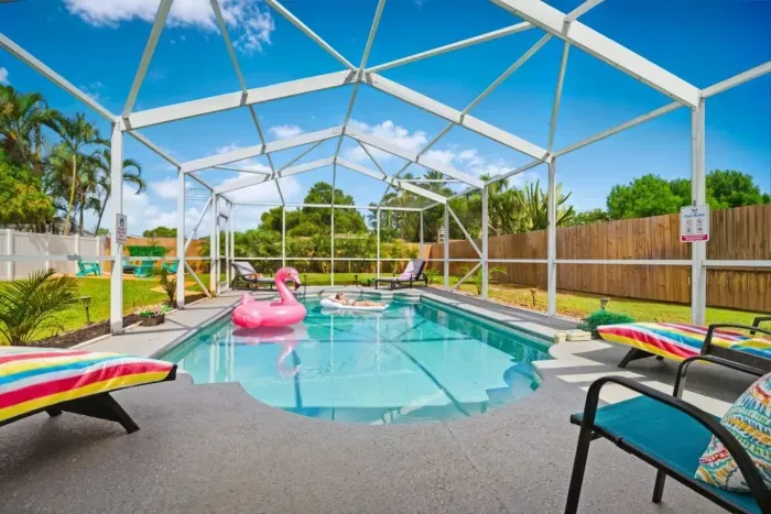 Private year-round pool with loungers, pool toys, and tropical surroundings, with heating included November through March.