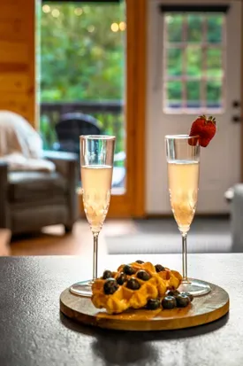 Cozy cabin vibes with bubbly, waffles, and peaceful forest views