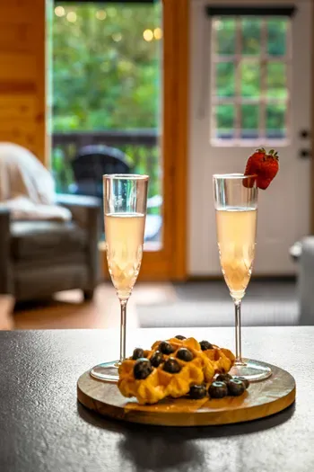 Cozy cabin vibes with bubbly, waffles, and peaceful forest views