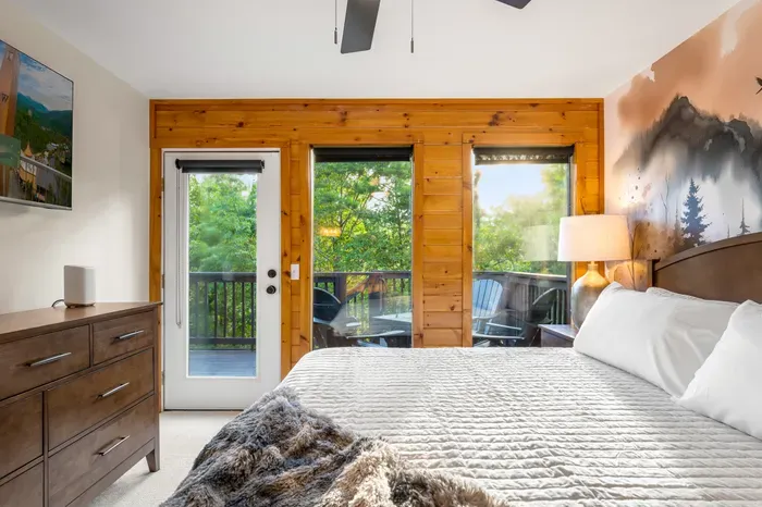 Cozy king bedroom with private deck access and peaceful wooded views