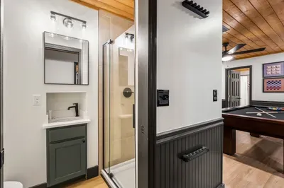 Modern bath with glass shower, steps from a stylish game room