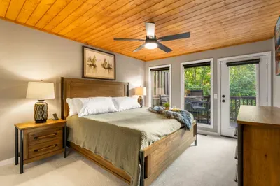 Cozy king bedroom with private deck access and warm wood accents