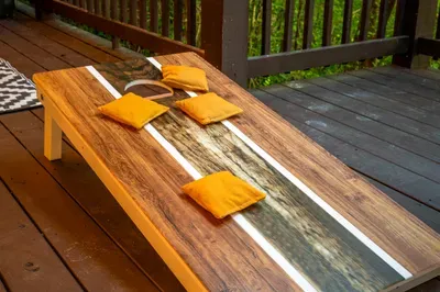 Outdoor deck cornhole setup for laid-back fun in a wooded setting