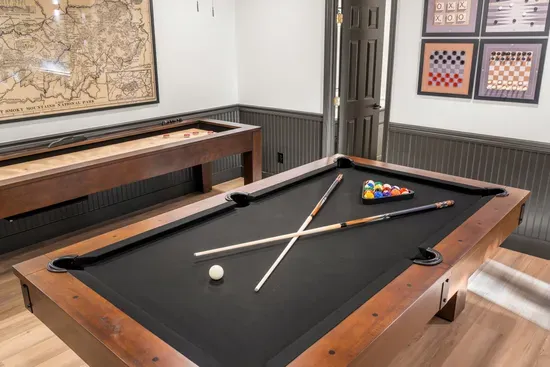 Private game room with pool table, shuffleboard, and stylish decor