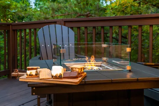 Cozy wooded deck with fire table and s’mores-ready outdoor seating