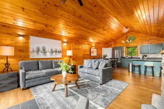 Cozy open-concept cabin living room with vaulted wood ceilings