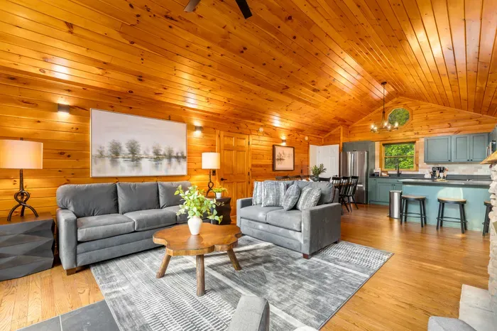 Cozy open-concept cabin living room with vaulted wood ceilings