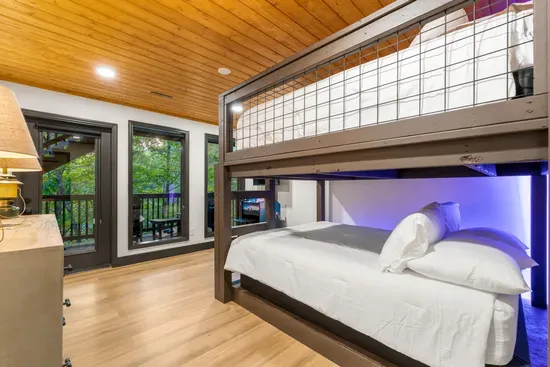 Modern bunk bedroom with wooded views and cozy cabin-style charm