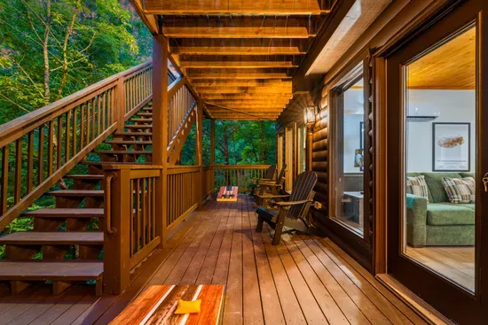 Spacious covered forest-view deck with cozy seating and warm cabin charm