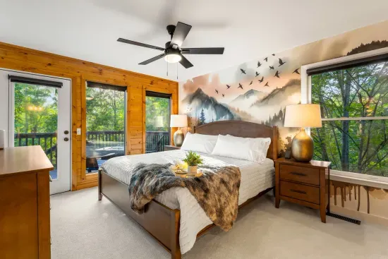 Cozy king suite with forest views, mountain mural, and private deck access