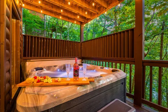 Private covered hot tub deck with string lights and serene forest views