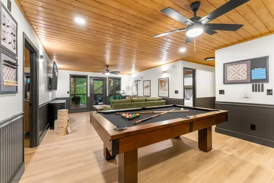 Spacious game room with pool table, TV, and cozy lounge seating