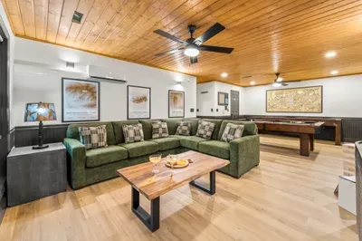 Spacious game lounge with cozy sectional and full shuffleboard table