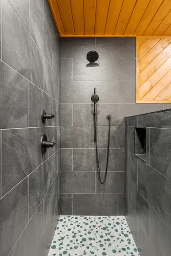 Spa-style walk-in shower with rainfall head, wood ceiling, and modern tile