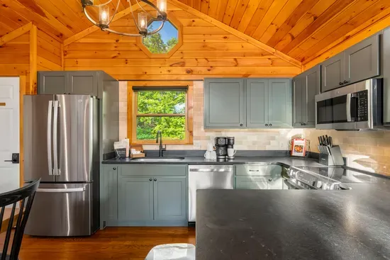 Rustic-modern kitchen with vaulted wood ceilings and stainless appliances