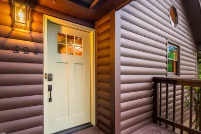 Warm cabin entry with covered porch and inviting front door